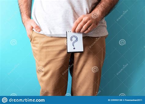 A Man In Beige Jeans Holds A Notepad With Question Mark Close Up Blue
