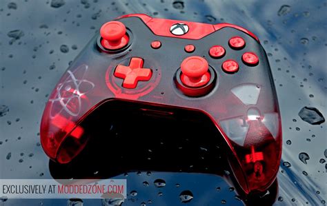 A Close Up Of A Red And Black Controller In The Water With Drops On It