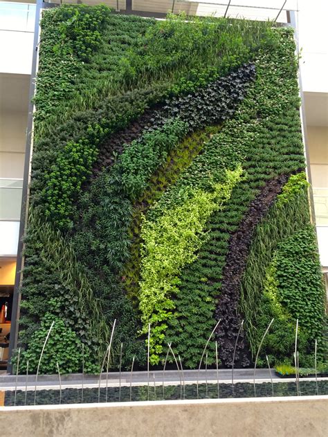 A Large Green Wall In The Middle Of A Building With Lots Of Plants