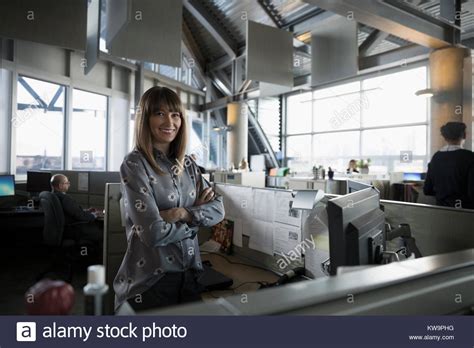Portrait Confidentsmiling Businesswoman In Office Cubicle Stock Photo