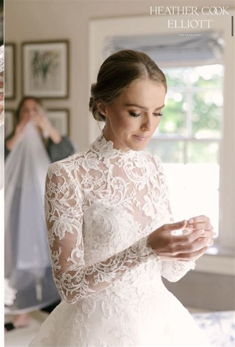 A Woman In A Wedding Dress Looking Down At Her Cell Phone While She Is