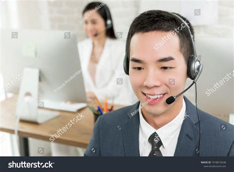 Smiling Male Asian Customer Service Telemarketing Agent Working In Call