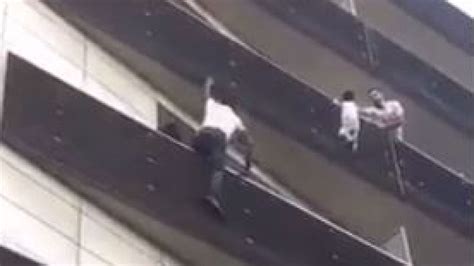 Video Man Risks His Life To Reach Child Dangling From Balcony News