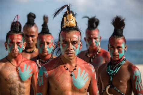 A Group Of Men With Painted Hands On Their Faces And Body Standing In