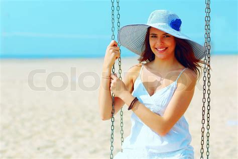 junge schöne frau sitzt auf einer schaukel am strand stock bild colourbox