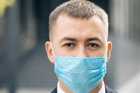 Close Up Of Face Of Young Handsome Businessman In Medical Mask Looking