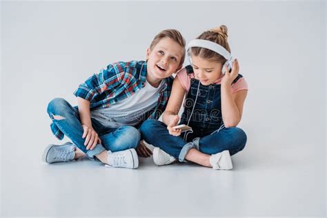 Kids Listening Music In Headphones While Sitting On The Floor Stock