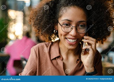 Smiling Young African American Woman Talking On Cellphone In Cafe Stock