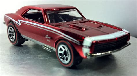 A Red Toy Car With Chrome Rims Sitting On A Table