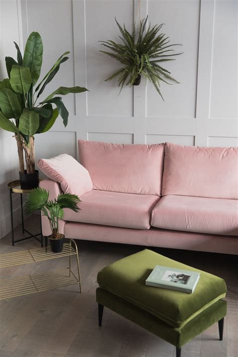 A Living Room With Pink Couches And Potted Plants