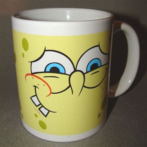 A Yellow And White Coffee Mug With Blue Eyes