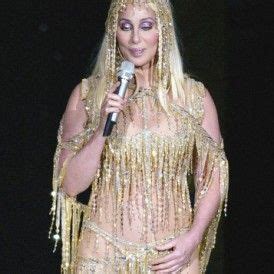 Lady In Gold Costume Holding A Microphone On Stage