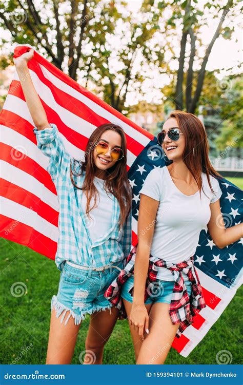 Portrait Of Two Beautiful Girls Holding An American Flag Celebrating Us Independence Day Fun
