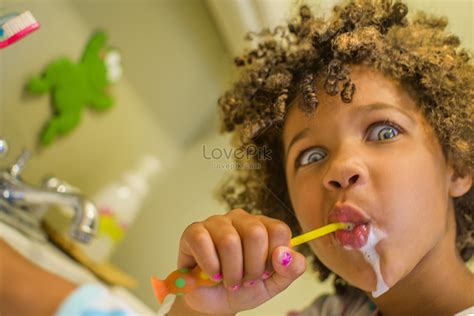 Portrait Of Girl Pulling Face While Brushing Teeth Picture And Hd
