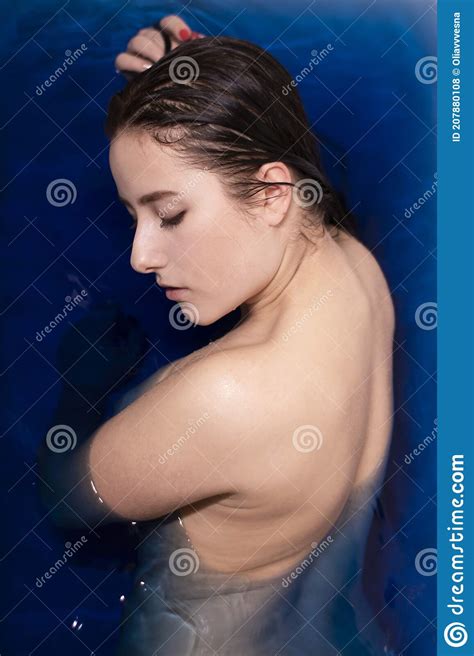 Portrait Of Attractive Brunette Woman Topless In Blue Liquid In