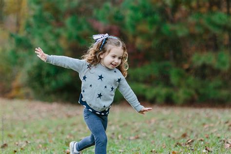 Happy Toddler Running On A Field With Leaves By Stocksy Contributor