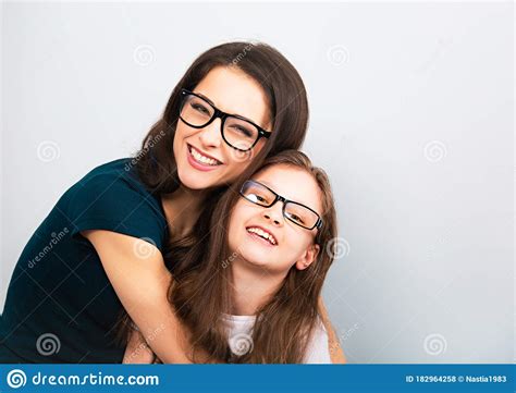 Happy Young Casual Mother And Smiling Kid In Fashion Glasses Hugging On