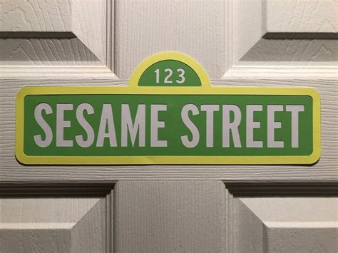 A Green And White Sign That Says Sesame Street On Its Front Door Frame