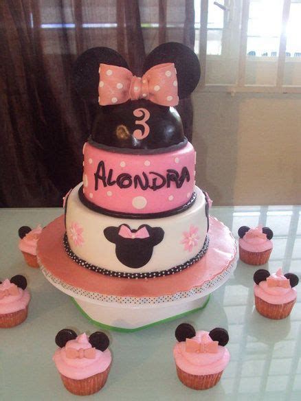 A Minnie Mouse Cake And Cupcakes On A Table