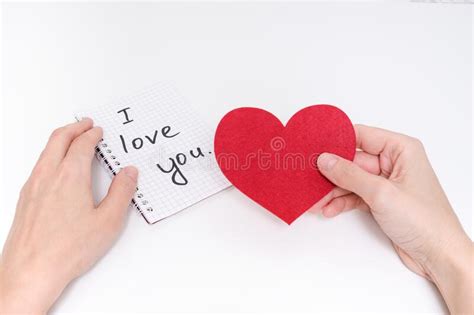 Hands Holding Red Heart And I Love You Sign Written In Notebook Stock