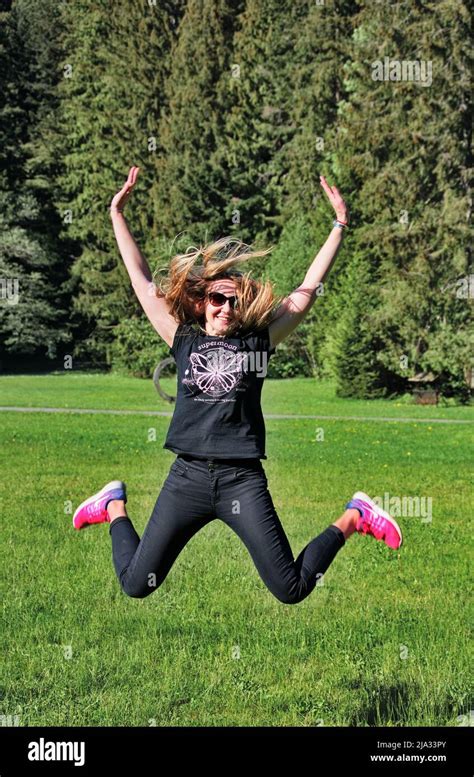 Mature Blond Woman Jumping On The Meadow Stock Photo Alamy