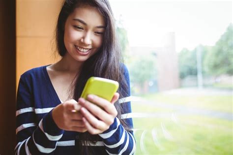 Premium Photo Smiling Student Using Smartphone