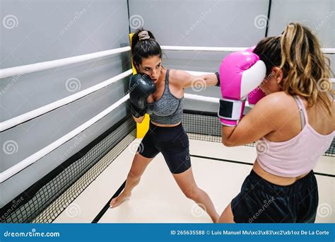 Two Women Practicing Punches In A Kickboxing Practice In The Ring Stock