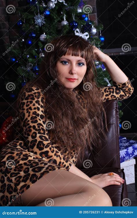 Beautiful Legged Redhead Model In Minidress And Stockings Posing At Christmas Tree Stock Image