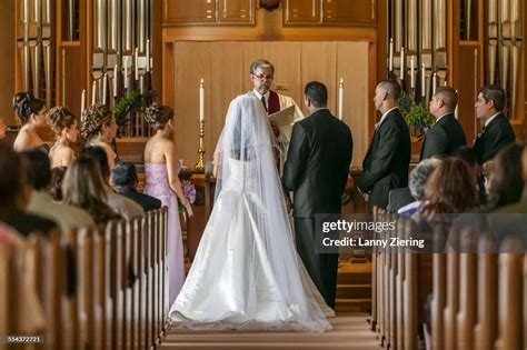 Bride And Groom Standing At Altar During Wedding Ceremony High Res