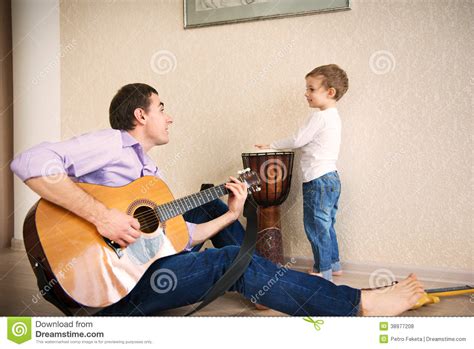 Padre Joven Y Pequeño Hijo Que Tocan La Guitarra Foto De