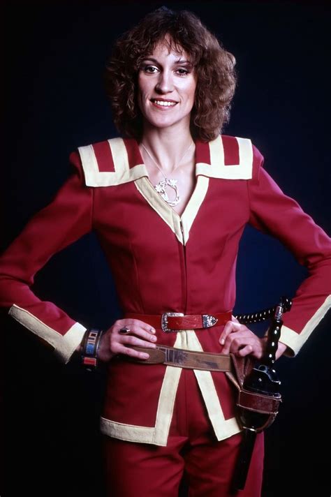A Woman In A Red And White Uniform Posing For A Photo With Her Hands On