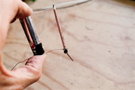 Tape one end of the metal wire to the positive end of the battery with the electrical tape. Simple electromagnet - stefan klocek