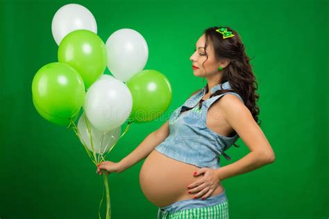 Pregnant Woman With Balloons On A Green Background He Looks At His Tummy In Anticipation Stock