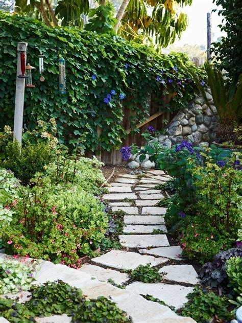 A Stone Path Surrounded By Plants And Flowers