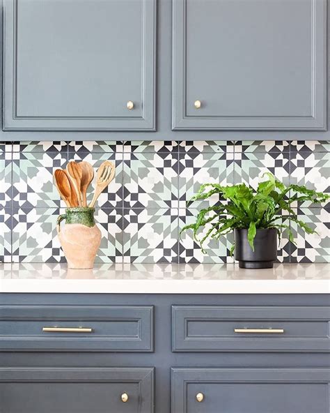 A Kitchen Counter With Blue Cabinets And Potted Plants On The Counter