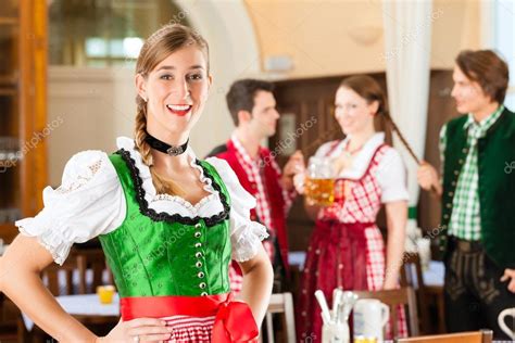 People In Traditional Bavarian Tracht In Restaurant Or Pub Stock Photo