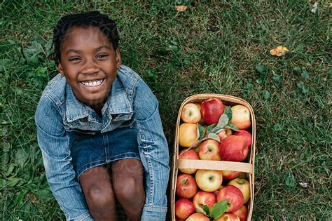 Smiling African American Girl Next To A Basket Of Apples By Gabriel