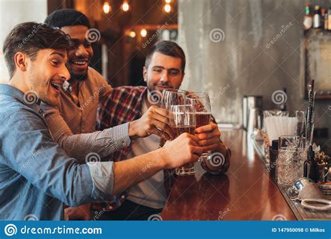 Male Friends Drinking Beer And Talking In Bar Stock Photo Image Of