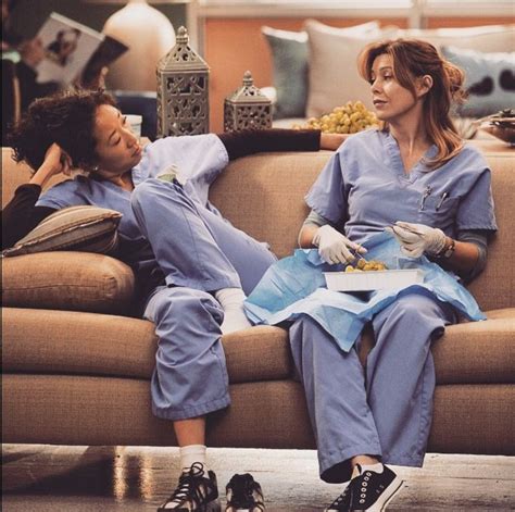Two Women In Scrubs Sitting On A Couch