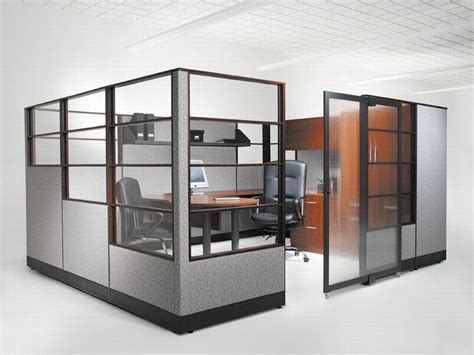 An Office Cubicle With Glass Partitions And Wooden Desk In The Center