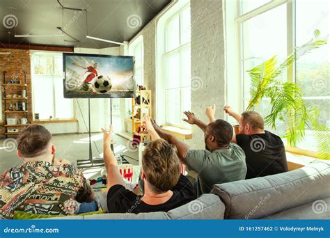 Group Of Friends Watching Football Or Soccer Game On Tv At Home Stock