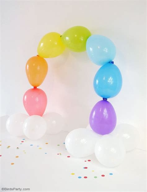 a bunch of balloons that are in the shape of a rainbow arch on a white background