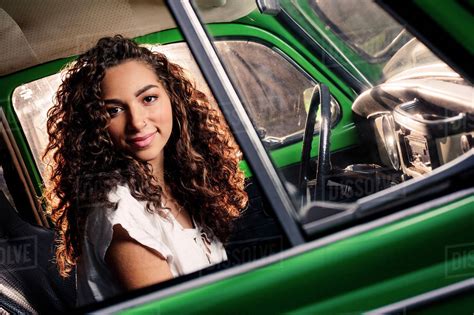 Mixed race woman driving vintage car - Stock Photo - Dissolve
