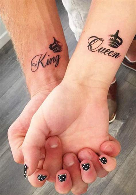 two people holding hands with tattoos on their arms and the words queen and king written in