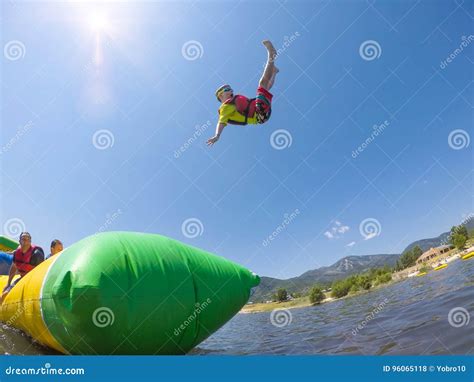 Little Boy Playing On Inflatable Water Toy At The Lake Stock Photo