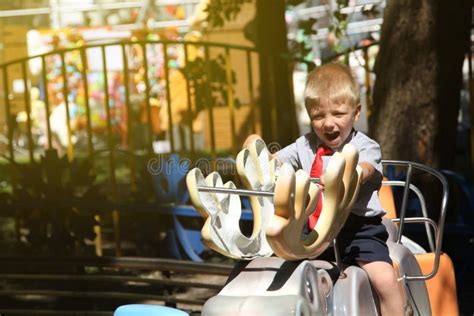 Little Boy With A Red Tie Riding A Carousel Stock Photo Image Of Luna