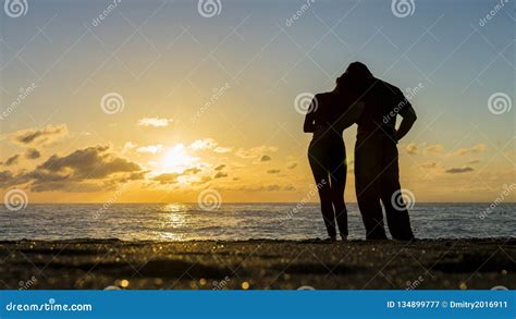 Silhouette Of Couple On The Beach With A Beautiful Sunset In Background