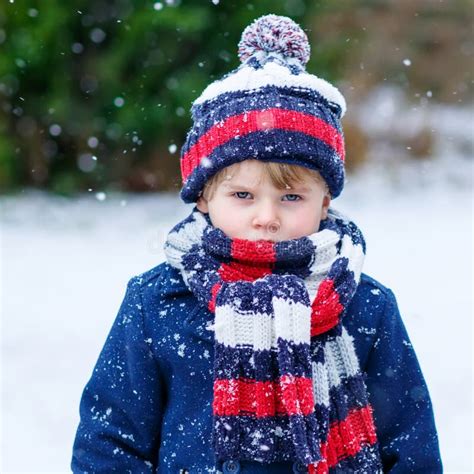 Sad Kid Boy In Colorful Winter Clothes Having Fun With Snow Out Stock