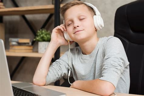 Niño Escuchando Música En Oficina Foto Gratis
