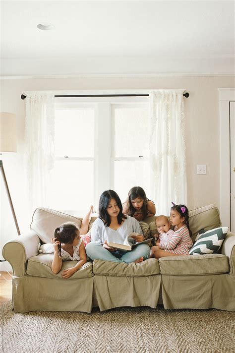 Mom And Four Daughters On Couch Reading For Homeschool By Stocksy Contributor Kristin Rogers